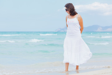young woman walking near blue sea.