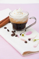 Coffee with cream on white towel and pink background