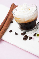 Coffee with cream on white towel and pink background