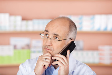 apotheker am telefon blickt ernst