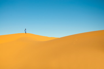 Fototapeta na wymiar Tapeta z wydm z Tuaregów człowieka na horyzoncie