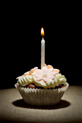 Birthday muffin with small burning candle