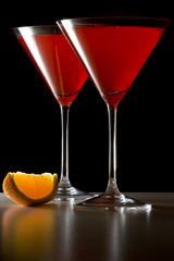 Red Cocktails in Martini Glasses with Orange Wedge