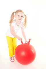 Fototapeta na wymiar cute sly little girl doing gymnastic exercise with ball