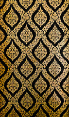 Golden Thai pattern on black wall