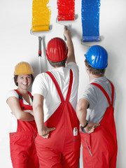 Female painter apprentice at work with two colleagues