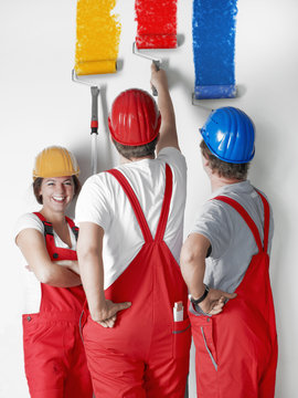 Female painter apprentice at work with two colleagues