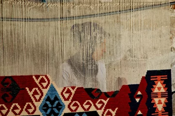 Fotobehang Woman weaves a traditional Turkish carpet © salajean