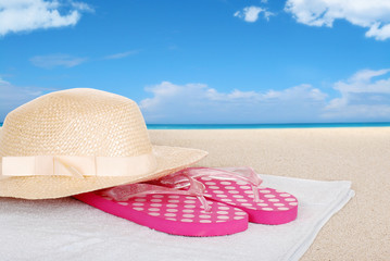 straw hat sandals on a beach towel