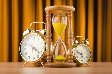 Alarm clocks and hourglass in time concept