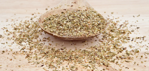chopped oregano marjoram leaves on wooden serving spoon