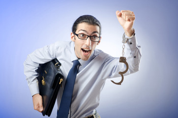 Businessman with handcuffs running away