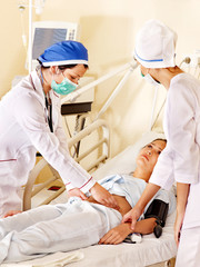 Doctor treats patient with stethoscope.