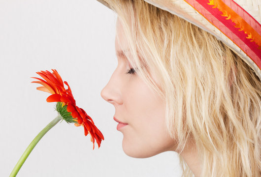 Young Blonde Woman Smelling A Flower