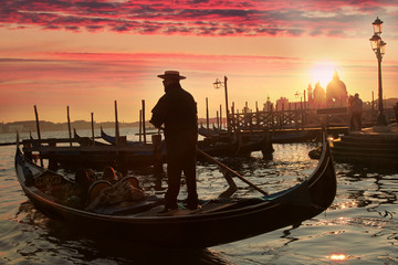 Fototapeta premium Gondolier against sunset in Venice, Italy