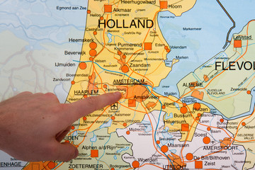 A Dutch map with a hand pointing to the capital city Amsterdam