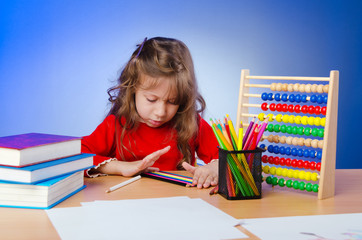 Little girl drawing with pencils