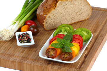 Geschnittene Bio Tomaten mit Brot auf Schneidebrett