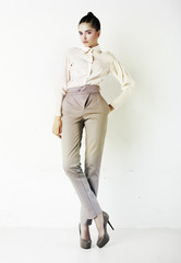 Young stylish brunette woman in white blouse and pants