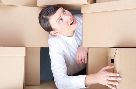 Portrait of young woman surrounded by lots of boxes
