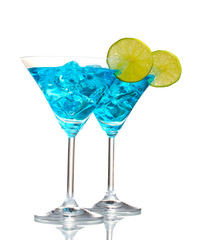Blue cocktail in martini glasses with ice isolated on white