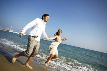Fototapeta na wymiar Man and woman running on beach