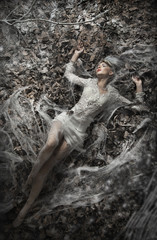 Fine art photo of a sexy woman lying on leaves