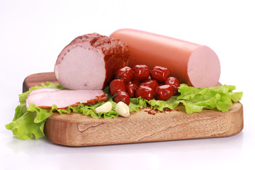Still Life with sausages, salami and ham on a wooden table