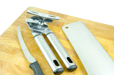 tin opener, cleaver and knife on chopping board