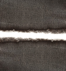 Piece of black jeans fabric with fringe on white