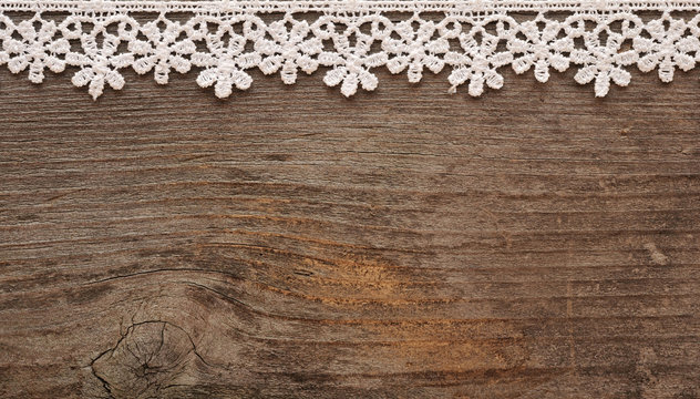 wooden background with white lace frame