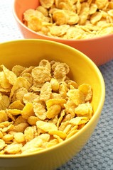 yellow and orange bowls with corn flakes