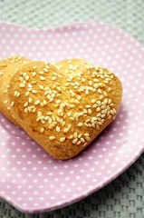 Cookies in the form of heart with sesame seeds on a plate