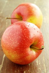 Two red apples on the old board