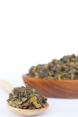 wooden spoon with dry leaf tea isolated on white