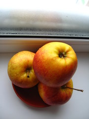 three nice apples on the window with snow