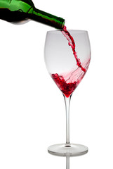 Pouring red wine in glass goblet isolated on white