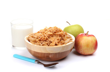 tasty cornflakes in wooden bowl, apples and glass of milk