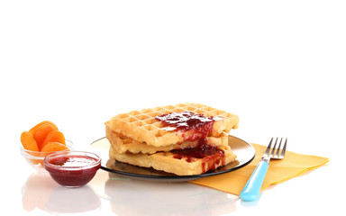 Tasty waffles with jam on plate isolated on white
