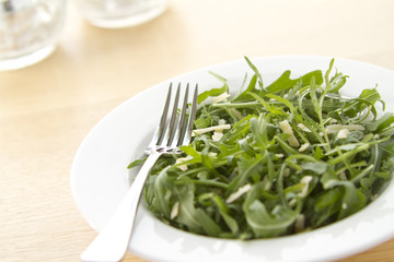 Rocket salad in white bowl on angle