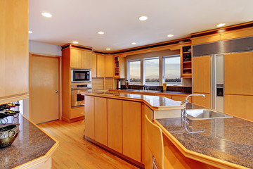 Large luxury modern wood kitchen with granite counter tops.