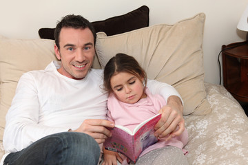 Father reading to his daughter