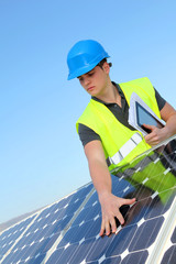 Young adult doing professional training on solar panels plant