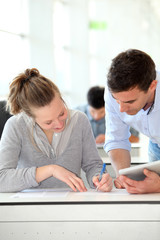 Teacher with student girl writing assignment