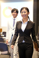 会場を出るビジネスマンとOL