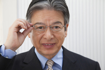 眼鏡のフレームを掴むビジネスマン