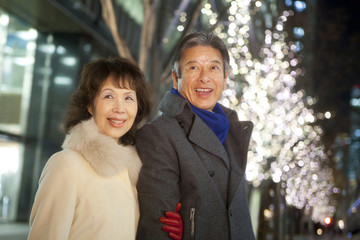 イルミネーションを眺める笑顔のシニアカップル © Paylessimages