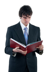 Businessman reading the big red book isolated on white