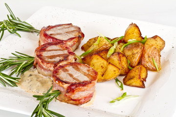 Grilled steak wrapped in bacon, with grilled vegetables