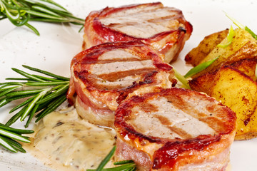 Grilled steak wrapped in bacon, with grilled vegetables